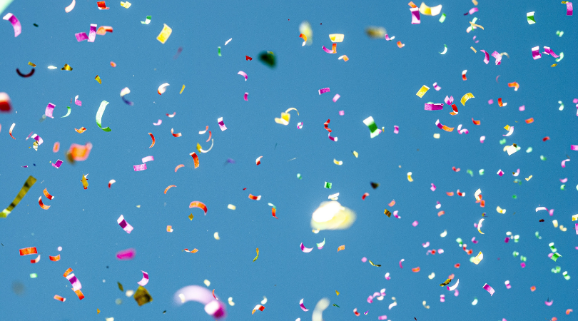 Confetti floating infront of a blue background