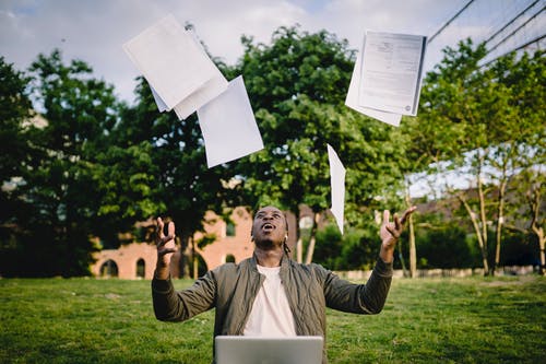 Man throwing graduation papers in the air