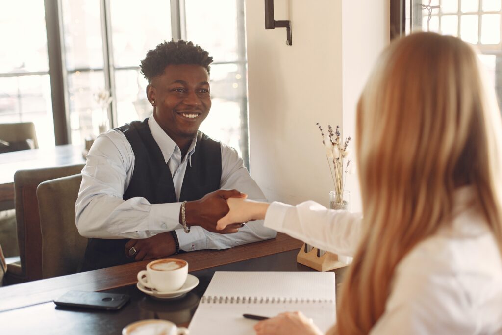 two people shaking hands over a table