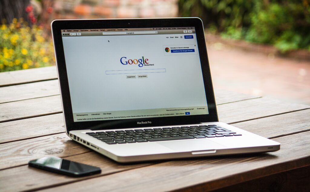 laptop displaying google's hompage on a wooden table